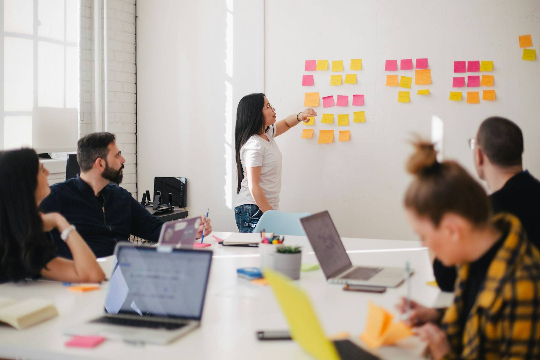 Equipo de trabajo colaborando alrededor de una mesa durante una sesión de estrategia